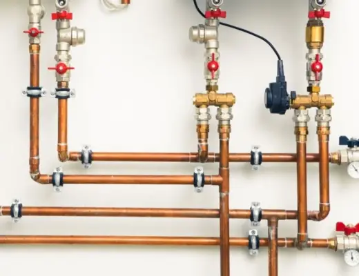 Une tuyauterie en cuivre reliée à un mur